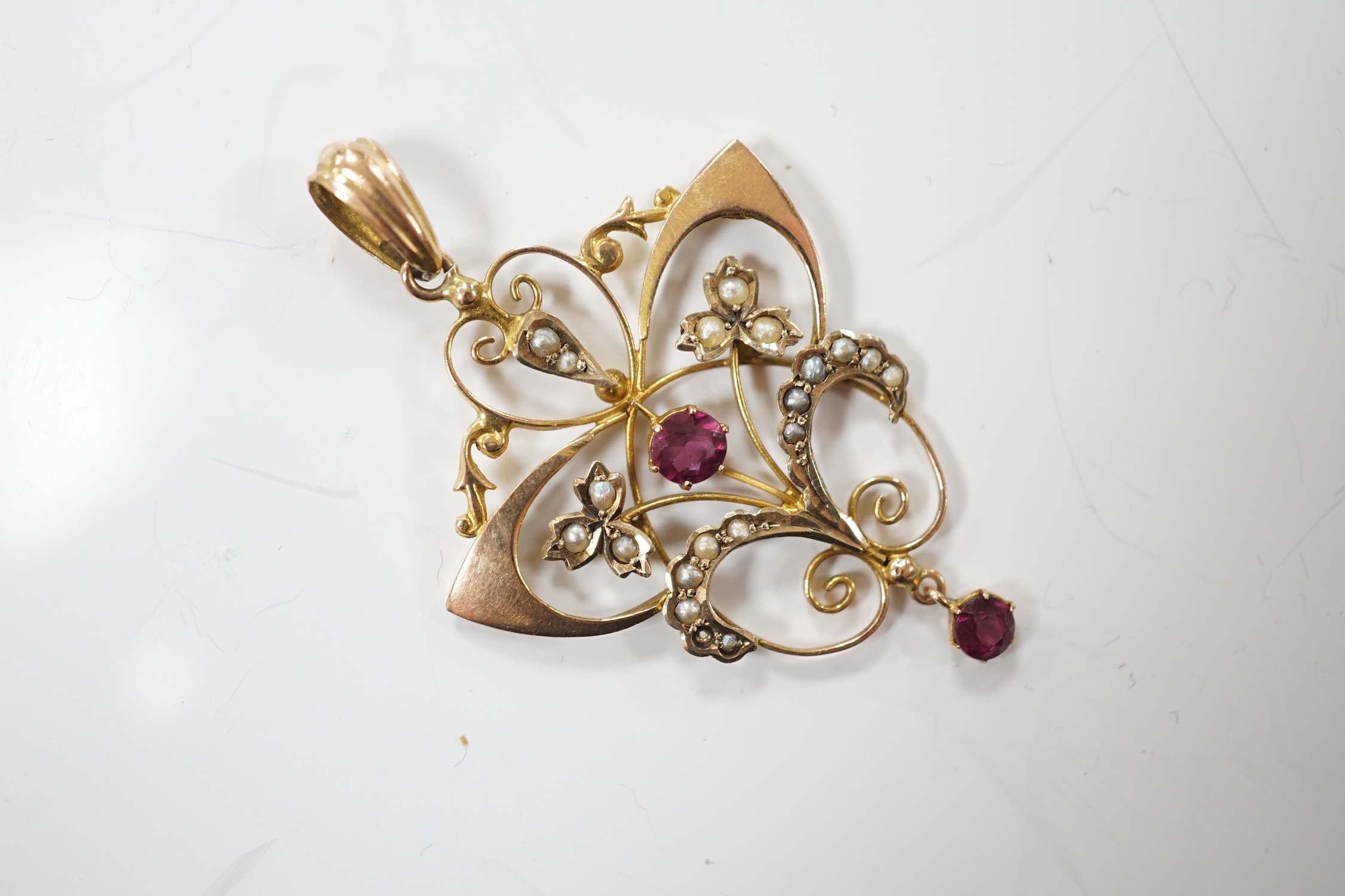 An Edwardian 9ct, garnet and seed pearl cluster set drop pendant, overall 47mm, gross weight 2.8 grams.